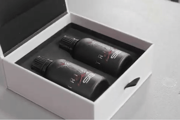 Detailing technician applying ceramic coating liquid onto a microfiber applicator pad before installation.